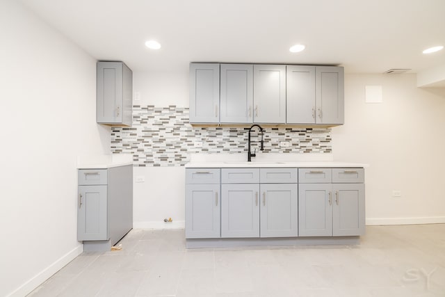 kitchen with sink, gray cabinetry, backsplash, and light tile patterned floors