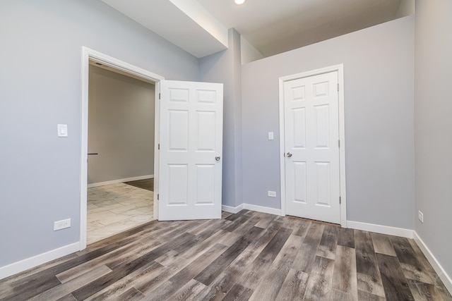 unfurnished bedroom featuring a closet and wood-type flooring