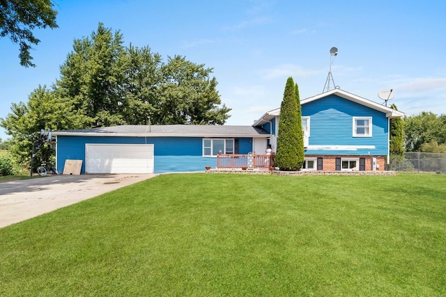 tri-level home featuring a garage and a front lawn