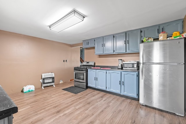 kitchen with blue cabinets, light hardwood / wood-style flooring, and appliances with stainless steel finishes