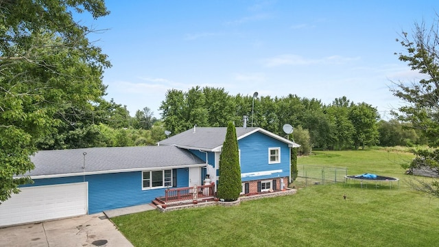 view of front of property with a garage, a trampoline, and a front yard