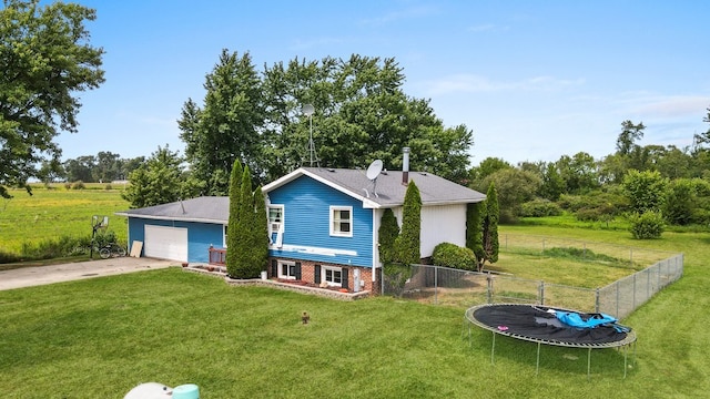 rear view of house with a trampoline and a yard