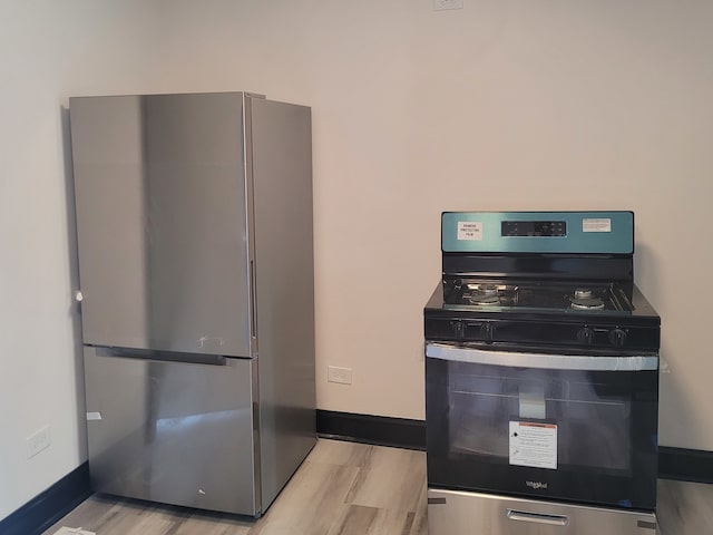 kitchen with stainless steel appliances and light hardwood / wood-style flooring