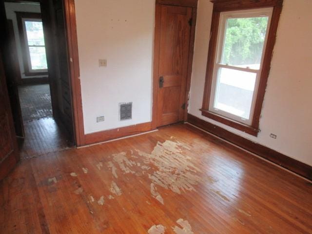 unfurnished room featuring wood-type flooring and a wealth of natural light