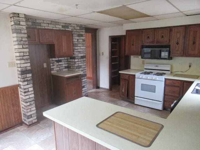 kitchen featuring white gas stove and a paneled ceiling