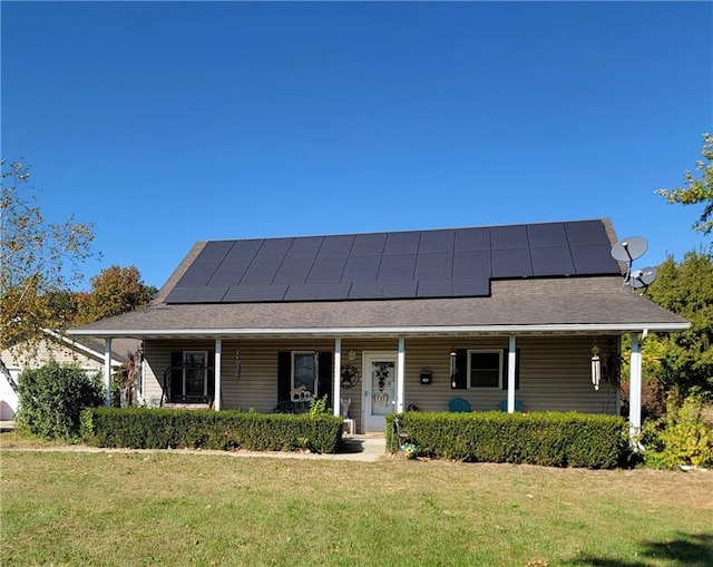 view of front of home featuring covered porch, a front yard, and solar panels