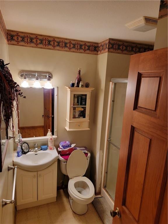 bathroom with vanity, a shower with shower door, and toilet