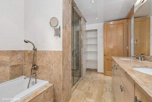 bathroom with shower with separate bathtub, double sink vanity, and tile patterned floors