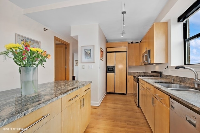 kitchen featuring sink, light wood-type flooring, light brown cabinetry, stone countertops, and stainless steel appliances