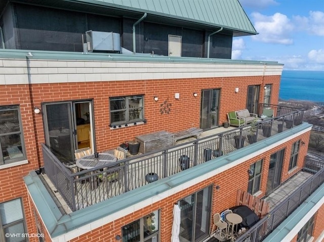 back of house featuring a balcony and a water view