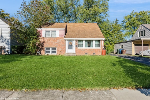 tri-level home featuring a front yard, driveway, and brick siding