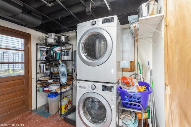 clothes washing area with stacked washer and dryer and laundry area