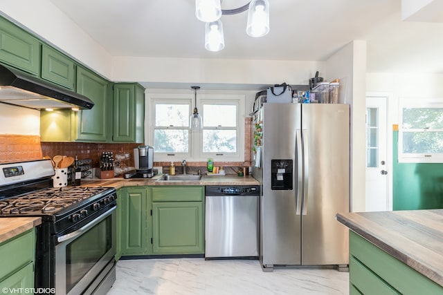 kitchen featuring butcher block counters, stainless steel appliances, backsplash, green cabinets, and sink