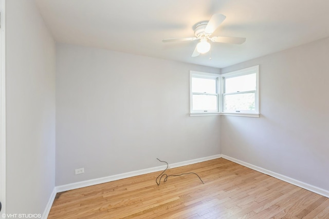 empty room featuring wood finished floors, a ceiling fan, and baseboards