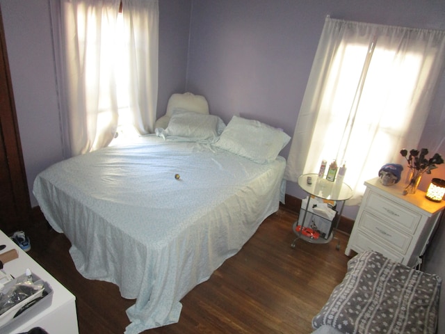 bedroom with dark wood-type flooring