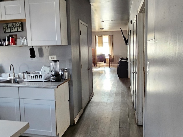 kitchen featuring white cabinetry, sink, and hardwood / wood-style flooring