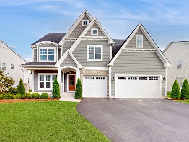 craftsman house with a front lawn and a garage