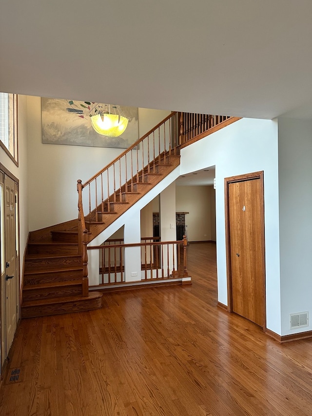 interior space with hardwood / wood-style flooring and a towering ceiling