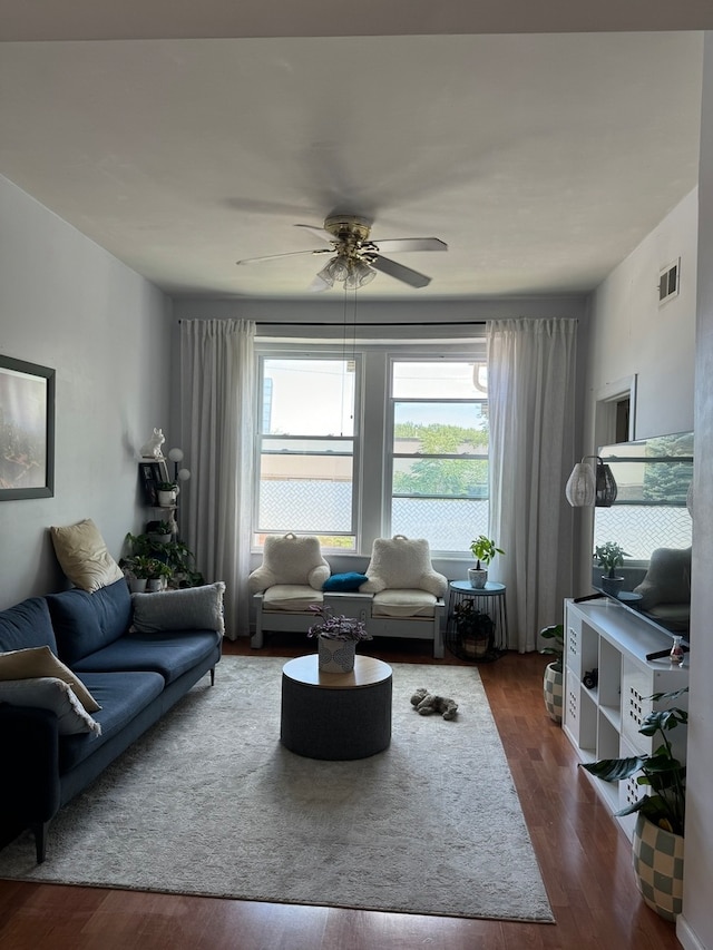 living room featuring ceiling fan and dark hardwood / wood-style flooring