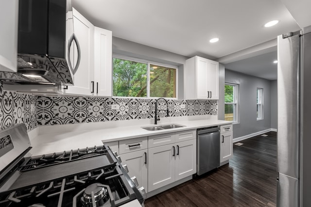 kitchen featuring stainless steel appliances, decorative backsplash, dark hardwood / wood-style floors, sink, and white cabinets