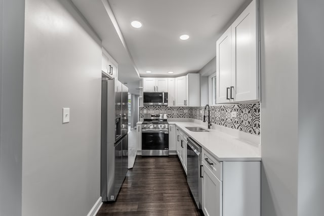 kitchen with backsplash, dark hardwood / wood-style flooring, white cabinets, sink, and stainless steel appliances