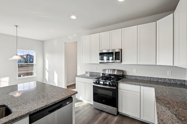 kitchen featuring white cabinetry, pendant lighting, dark stone countertops, and appliances with stainless steel finishes