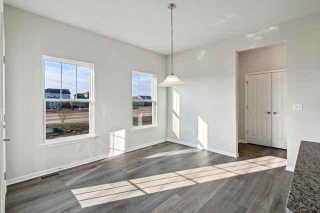 unfurnished dining area featuring dark hardwood / wood-style flooring