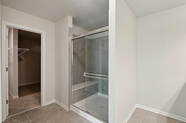 bathroom with tile patterned flooring and a shower with shower door