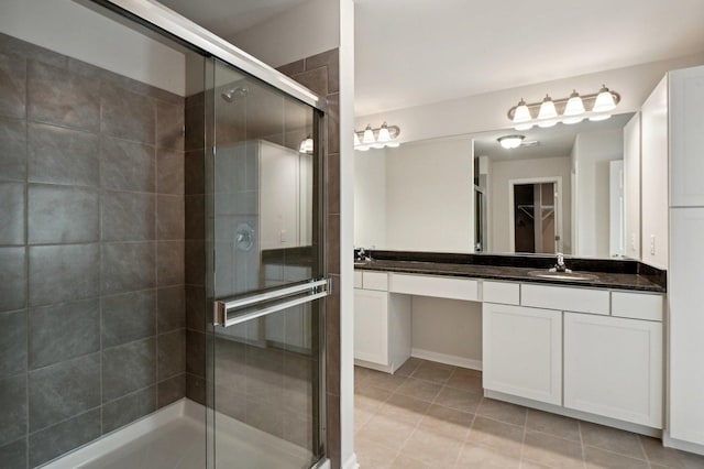 bathroom featuring vanity, tile patterned flooring, and walk in shower