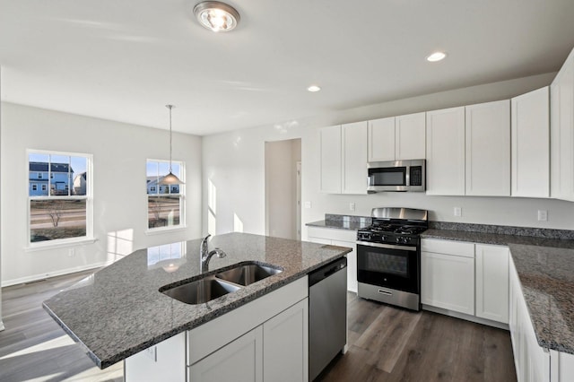 kitchen featuring white cabinetry, stainless steel appliances, a kitchen island with sink, and sink