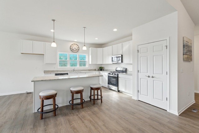 601 Virginia St, Elburn, IL 60119 - kitchen with light stone counters, a sink, light wood finished floors, a center island, and stainless steel appliances