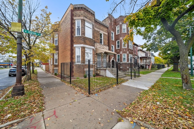 view of building exterior with a fenced front yard and a residential view