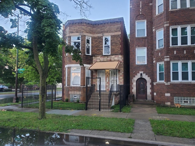 view of front facade with a fenced front yard and brick siding