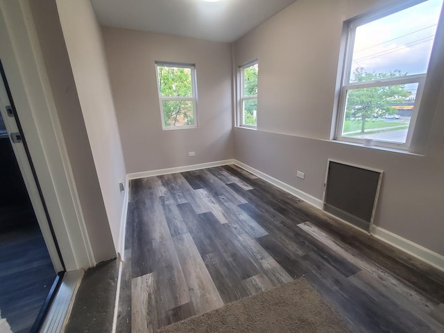 unfurnished room featuring dark wood-type flooring and baseboards