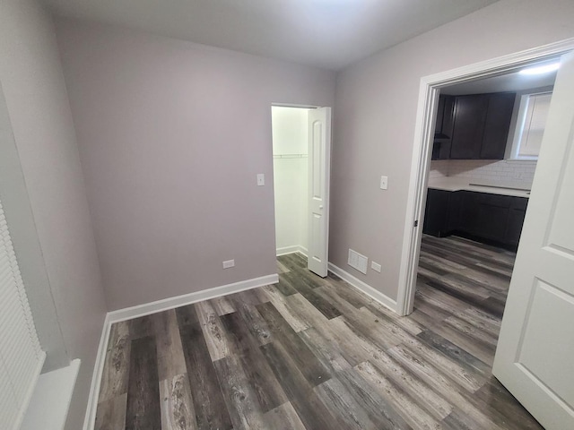 unfurnished bedroom with visible vents, baseboards, and dark wood-style flooring