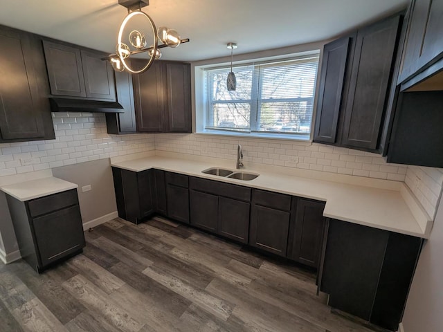 kitchen featuring a sink, backsplash, and dark wood-type flooring