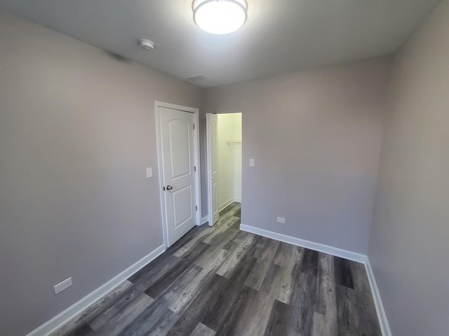 empty room with dark wood-style floors and baseboards