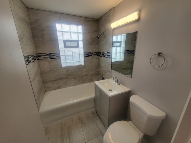 full bathroom with tiled shower / bath combo, vanity, and toilet