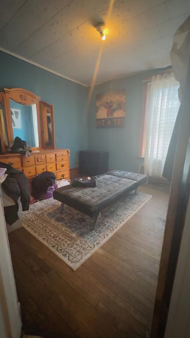 bedroom featuring ornamental molding and wood-type flooring