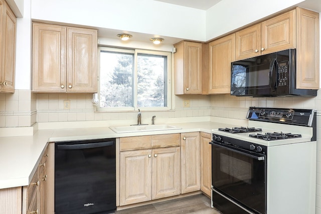 kitchen featuring light brown cabinetry, sink, black appliances, and dark hardwood / wood-style flooring