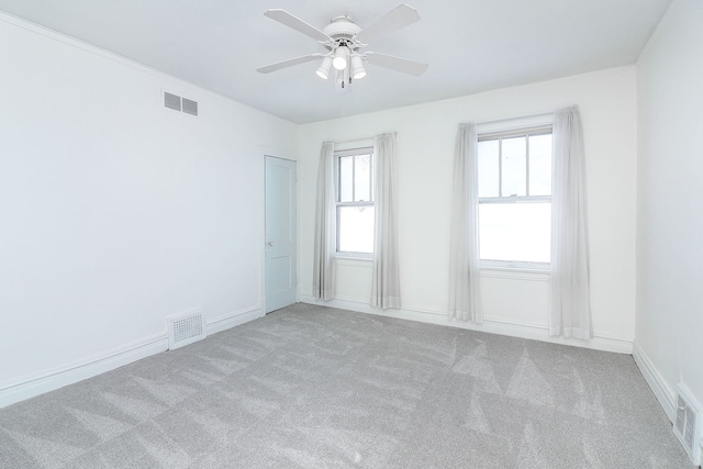 carpeted spare room featuring ceiling fan