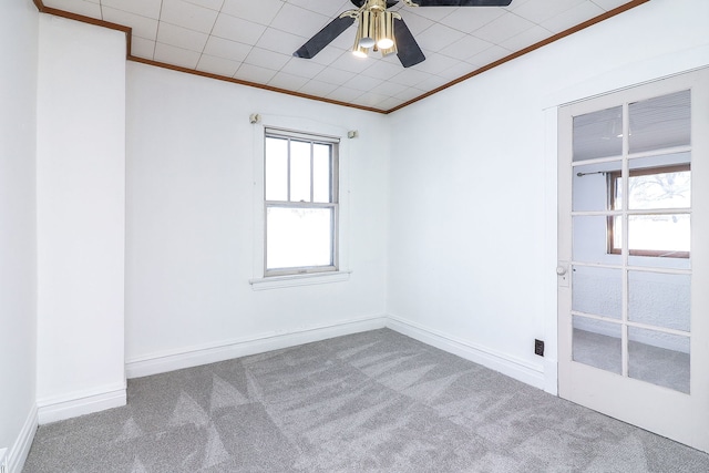 empty room with ceiling fan, crown molding, and carpet flooring