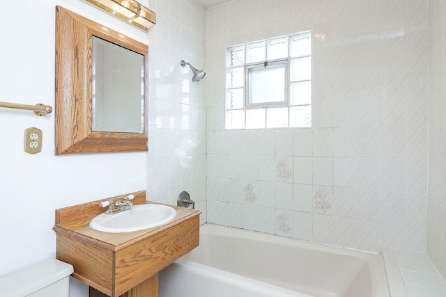 full bathroom featuring sink, toilet, and tiled shower / bath