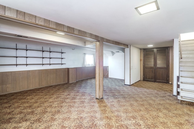 basement with light colored carpet and wooden walls