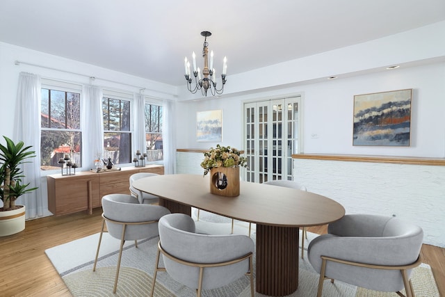 dining space featuring light wood-type flooring and a chandelier