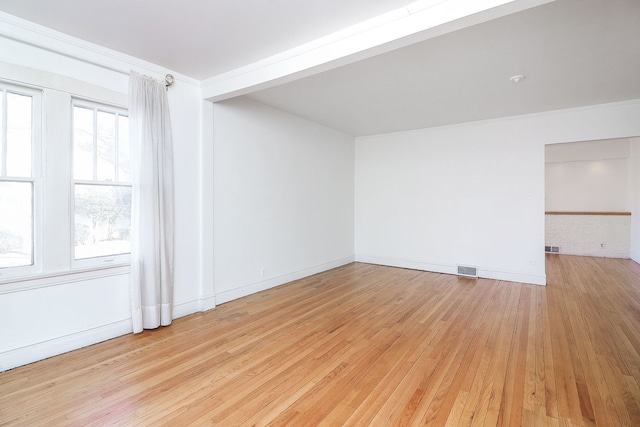 empty room with light hardwood / wood-style flooring and a healthy amount of sunlight