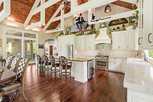 kitchen with premium range hood, sink, dark hardwood / wood-style flooring, high end appliances, and a center island