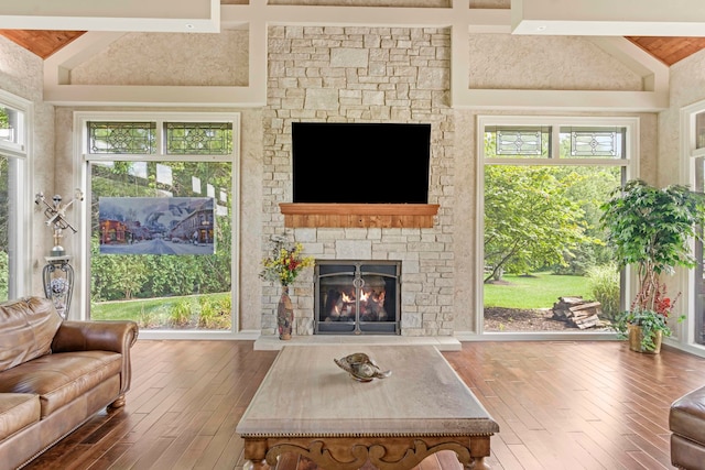 living room featuring a fireplace, hardwood / wood-style floors, and lofted ceiling with beams