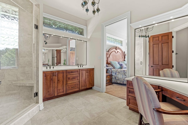 bathroom featuring tiled shower, a chandelier, tile patterned flooring, and vanity