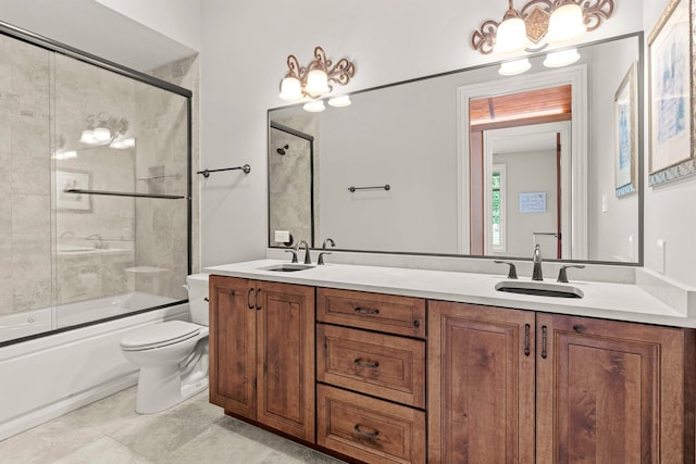 full bathroom featuring tile patterned flooring, shower / bath combination with glass door, toilet, and double sink vanity